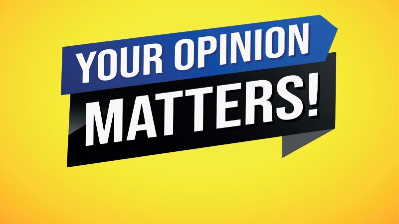 Das Bild zeigt ein blaues und ein schwarzes Schild auf gelbem Hintergrund mit der Beschreibung „Your Opinion Matters!“