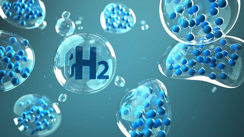 Das Bild zeigt Luftblasen mit verschiedenen Atomen und einer H2-Zapfanlage. 